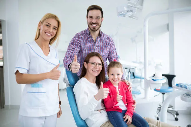 Familia sonriendo junto a su dentista en Clínica Dental Cocibolca